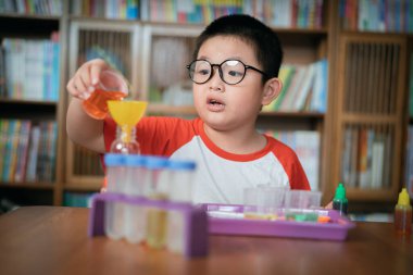 Küçük çocuk laboratuarda kimyasal deney yapıyor.