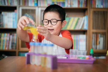 Küçük çocuk laboratuarda kimyasal deney yapıyor.