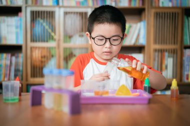 Küçük çocuk laboratuarda kimyasal deney yapıyor.