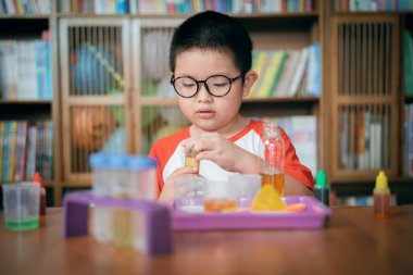 Küçük çocuk laboratuarda kimyasal deney yapıyor.