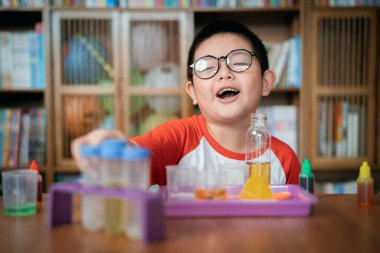 Küçük çocuk laboratuarda kimyasal deney yapıyor.