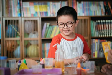 Küçük çocuk laboratuarda kimyasal deney yapıyor.