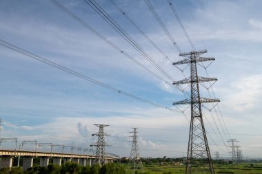 Elektrik iletim pilonu alacakaranlıkta mavi gökyüzüne karşı siluetlendi