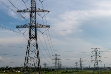 Elektrik iletim pilonu alacakaranlıkta mavi gökyüzüne karşı siluetlendi