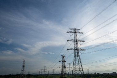 Elektrik iletim pilonu alacakaranlıkta mavi gökyüzüne karşı siluetlendi