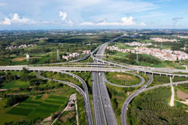 Aerial view of highway interchange Road junction Aerial photo of a highway going through the forest clipart