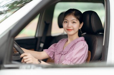 Yeni başlayan bir kadın sürücü arabada oturuyor.