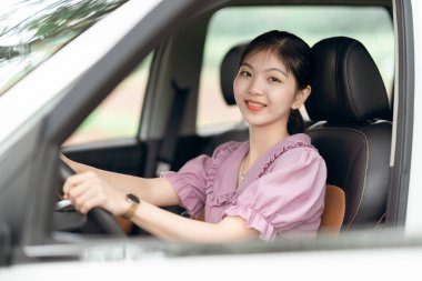 Yeni başlayan bir kadın sürücü arabada oturuyor.