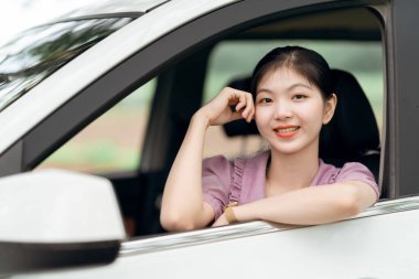 Yeni başlayan bir kadın sürücü arabada oturuyor.