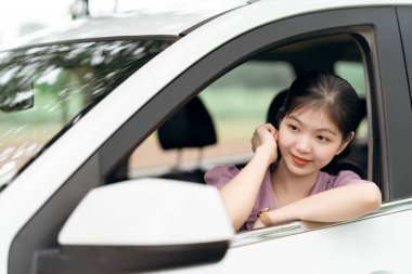 Yeni başlayan bir kadın sürücü arabada oturuyor.