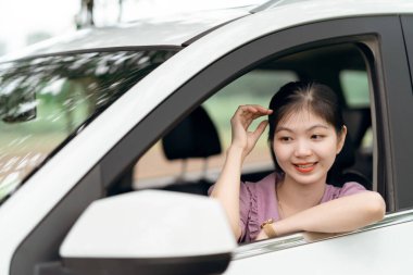 Yeni başlayan bir kadın sürücü arabada oturuyor.