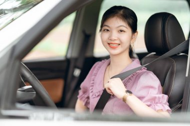 Yeni başlayan bir kadın sürücü arabada oturuyor.