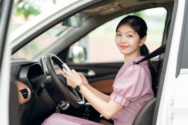 Yeni başlayan bir kadın sürücü arabada oturuyor.