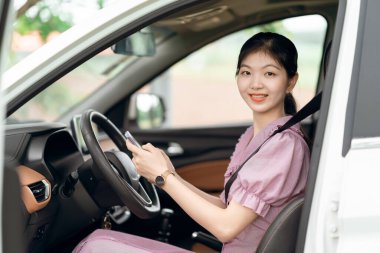 Yeni başlayan bir kadın sürücü arabada oturuyor.