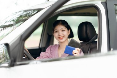 Yeni başlayan bir kadın sürücü arabada oturuyor.