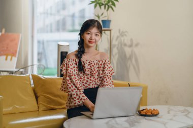 Güzel Asyalı kız evde çalışıyor.
