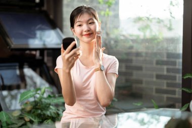 Asyalı kızlar avluda makyaj yapıyor.