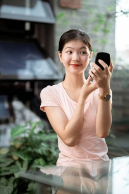 Asyalı kızlar avluda makyaj yapıyor.