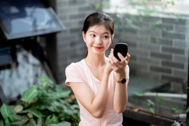 Asyalı kızlar avluda makyaj yapıyor.