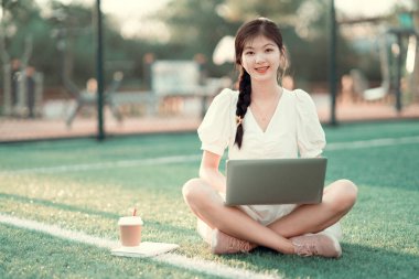 Üniversite öğrencileri futbol sahalarında dizüstü bilgisayar kullanıyorlar