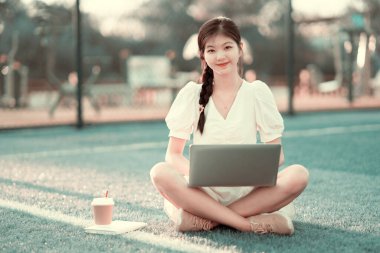 Üniversite öğrencileri futbol sahalarında dizüstü bilgisayar kullanıyorlar