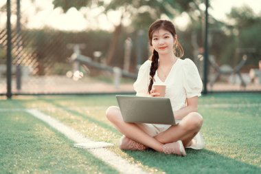 Üniversite öğrencileri futbol sahalarında dizüstü bilgisayar kullanıyorlar