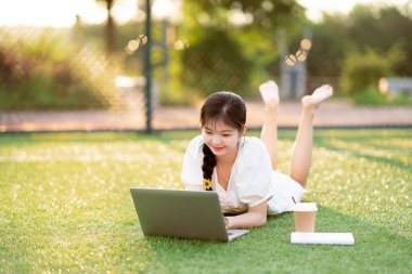 Üniversite öğrencileri futbol sahalarında dizüstü bilgisayar kullanıyorlar