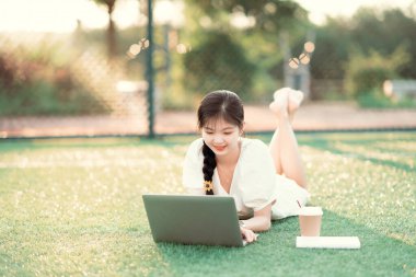 Üniversite öğrencileri futbol sahalarında dizüstü bilgisayar kullanıyorlar