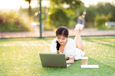 Üniversite öğrencileri futbol sahalarında dizüstü bilgisayar kullanıyorlar