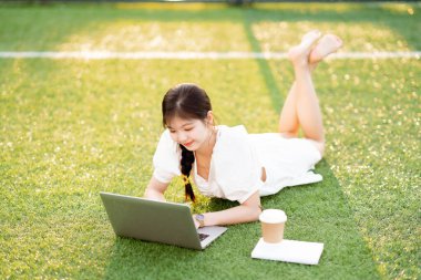 Üniversite öğrencileri futbol sahalarında dizüstü bilgisayar kullanıyorlar