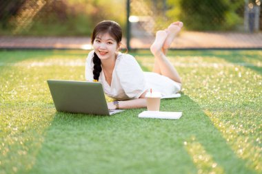 Üniversite öğrencileri futbol sahalarında dizüstü bilgisayar kullanıyorlar