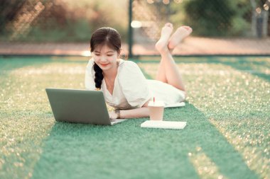 Üniversite öğrencileri futbol sahalarında dizüstü bilgisayar kullanıyorlar