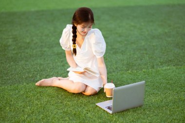 Üniversite öğrencileri futbol sahalarında dizüstü bilgisayar kullanıyorlar