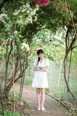 Bayan üniversite öğrencileri parkta kitap okurlar.