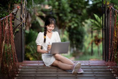 Bayan üniversite öğrencileri kampüste dizüstü bilgisayar kullanıyorlar.