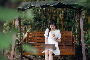 Bayan üniversite öğrencileri kampüste dizüstü bilgisayar kullanıyorlar.