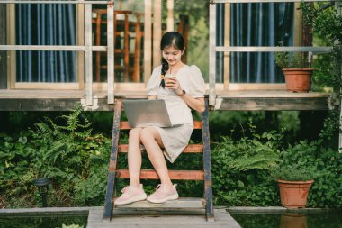 Bayan üniversite öğrencileri kampüste dizüstü bilgisayar kullanıyorlar.