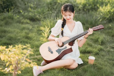 Kız parkta gitar tıngırdatıyordu.