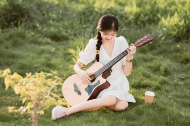 Kız parkta gitar tıngırdatıyordu.