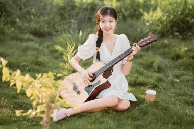 Kız parkta gitar tıngırdatıyordu.