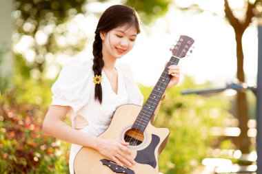 Kız parkta gitar tıngırdatıyordu.