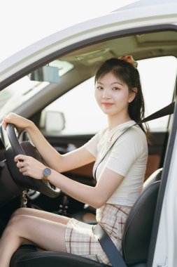 Yeni başlayan bir kadın sürücü arabada oturuyor.