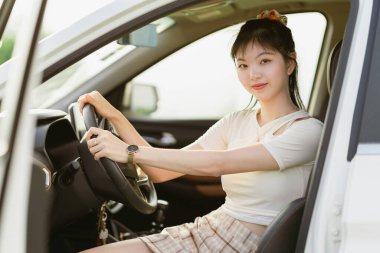 Yeni başlayan bir kadın sürücü arabada oturuyor.