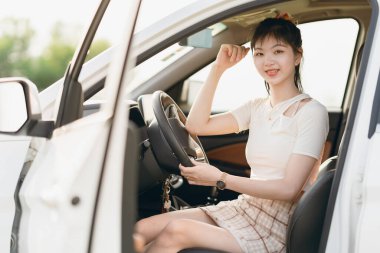 Yeni başlayan bir kadın sürücü arabada oturuyor.