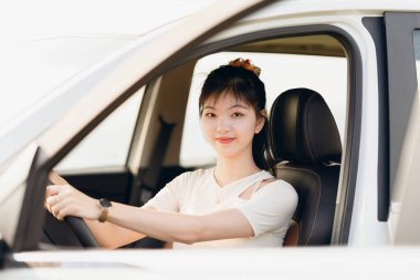 Yeni başlayan bir kadın sürücü arabada oturuyor.