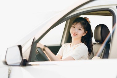 Yeni başlayan bir kadın sürücü arabada oturuyor.