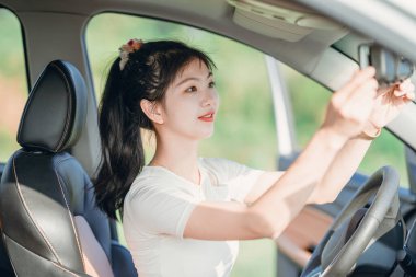 Yeni başlayan bir kadın sürücü arabada oturuyor.