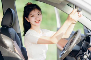 Yeni başlayan bir kadın sürücü arabada oturuyor.