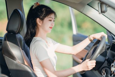 Yeni başlayan bir kadın sürücü arabada oturuyor.