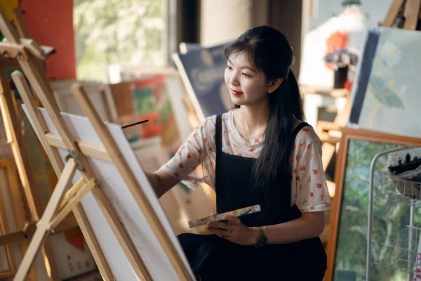 The girl is drawing in the studio